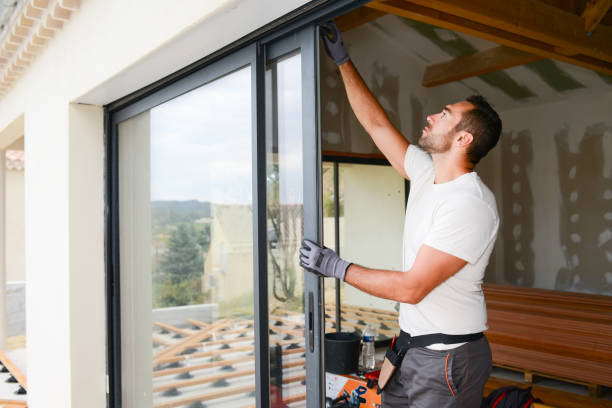 handsome young man installing bay window in a new house construction site